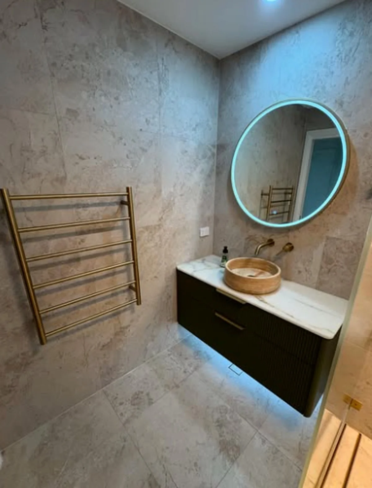 Stone tiled bathroom and floating vanity completed by D.J.R
